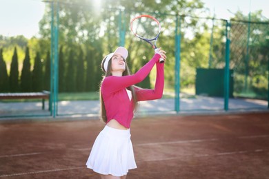 Photo of Beautiful woman playing tennis at court on sunny day