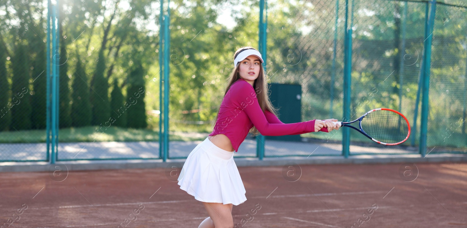 Beautiful woman playing tennis at court on sunny day Photo of Beautiful woman playing tennis at court on sunny day