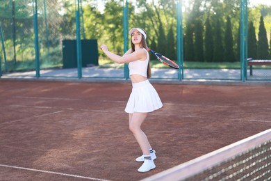 Photo of Beautiful woman playing tennis at court on sunny day