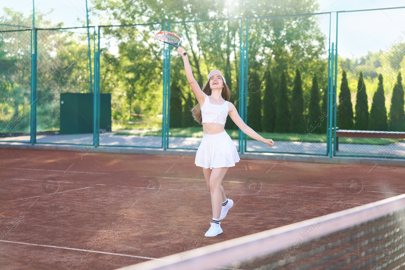 Beautiful woman playing tennis at court on sunny day Photo of Beautiful woman playing tennis at court on sunny day