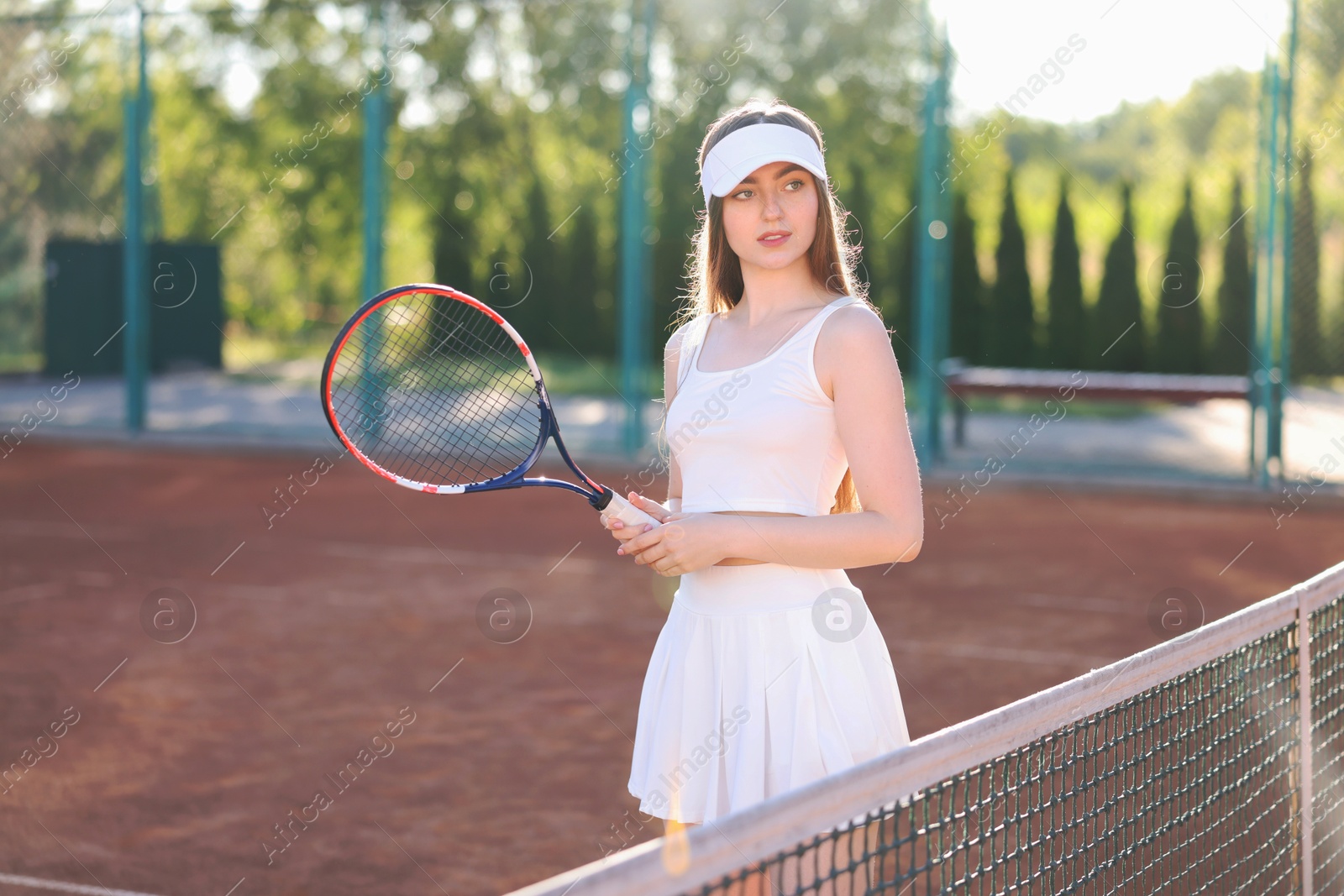 Beautiful woman with racket at tennis court Photo of Beautiful woman with racket at tennis court
