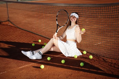 Photo of Beautiful woman with racket and balls at tennis court