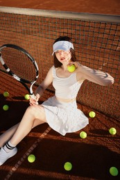 Photo of Beautiful woman with racket and balls at tennis court
