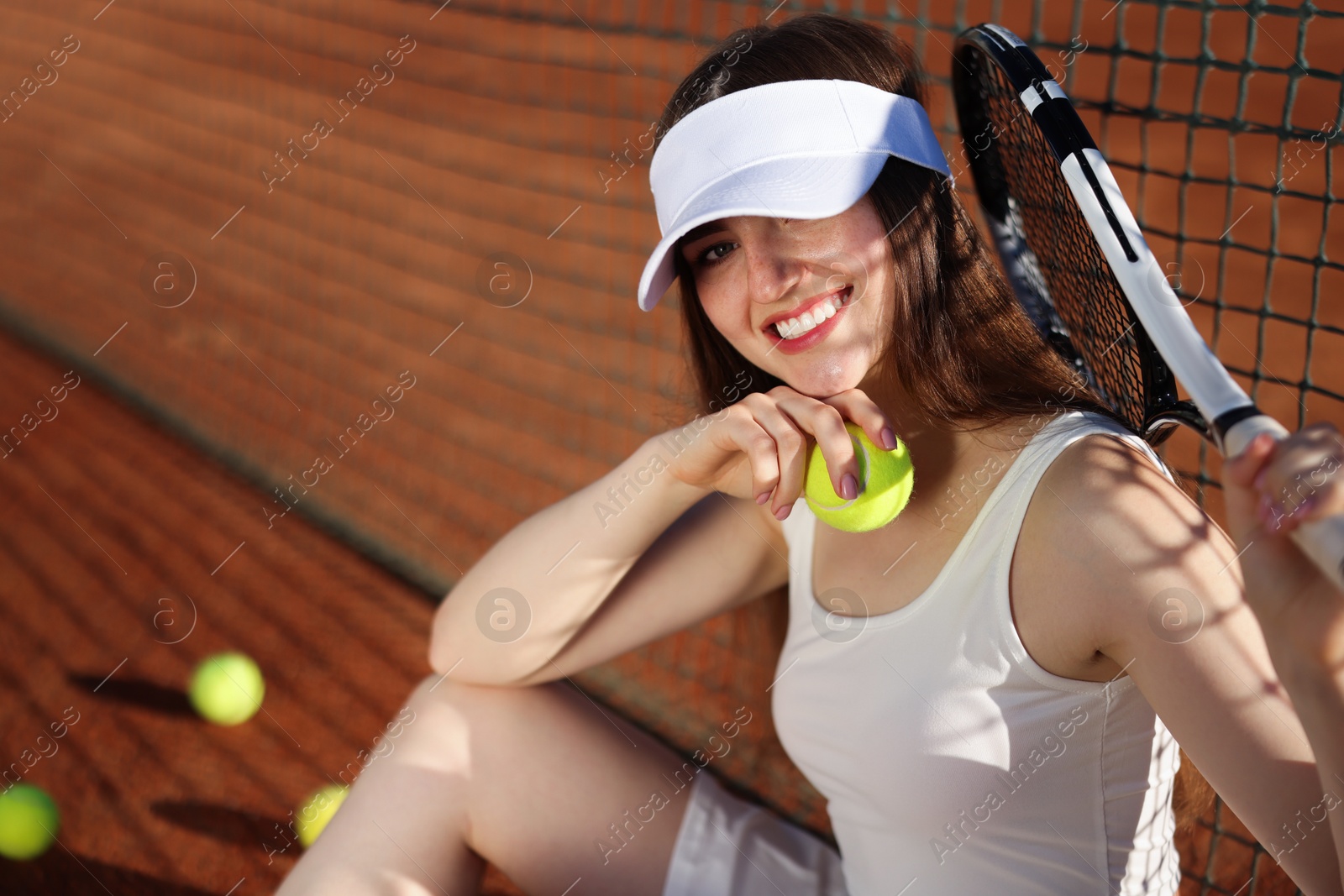 Beautiful woman with racket and ball at tennis court. Space for text Photo of Beautiful woman with racket and ball at tennis court. Space for text