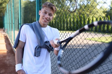 Photo of Young man with racket at tennis court