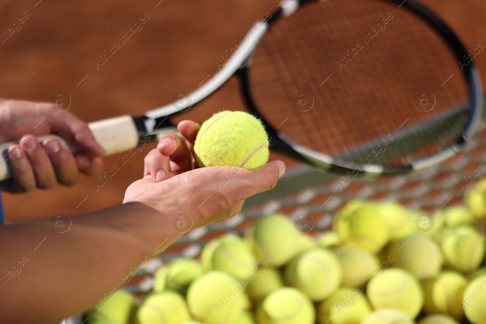 Man taking tennis ball out of cart at court, closeup Photo of Man taking tennis ball out of cart at court, closeup