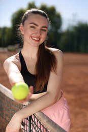 Photo of Happy woman with racket and ball at tennis court