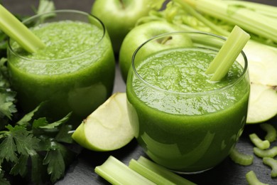 Photo of Superfood. Refreshing smoothie in glasses and ingredients on dark textured table, closeup