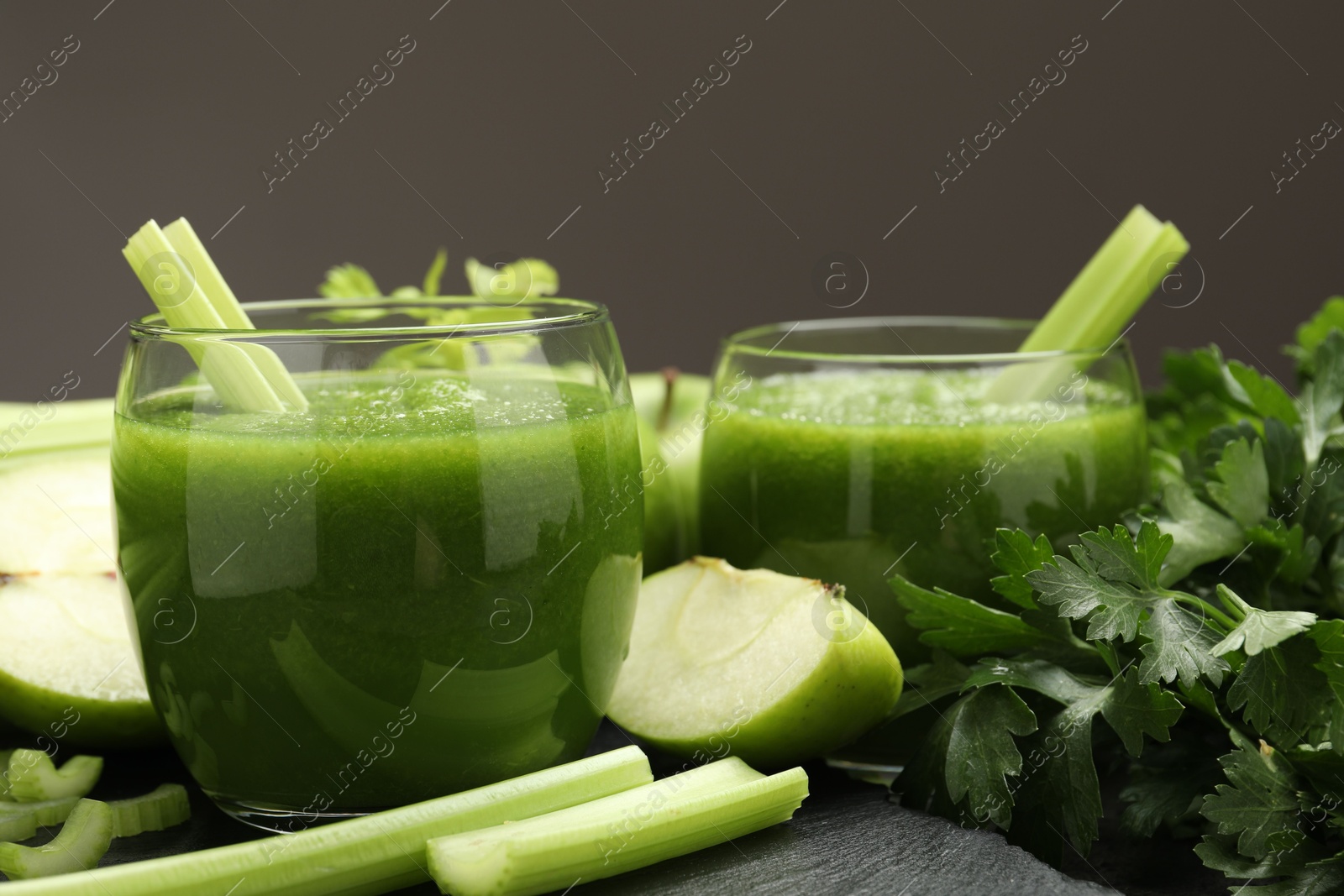 Superfood. Refreshing smoothie in glasses and ingredients on dark textured table against grey background, closeup Photo of Superfood. Refreshing smoothie in glasses and ingredients on dark textured table against grey background, closeup