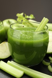 Photo of Superfood. Refreshing smoothie in glass and ingredients on dark textured table against grey background, closeup