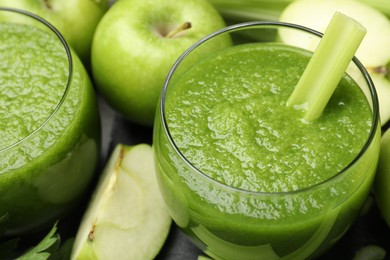 Photo of Superfood. Refreshing smoothie in glasses and ingredients on dark table, closeup