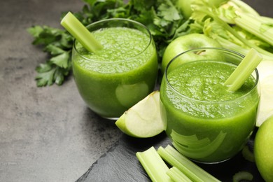 Photo of Superfood. Refreshing smoothie in glasses and apples on dark textured table, closeup
