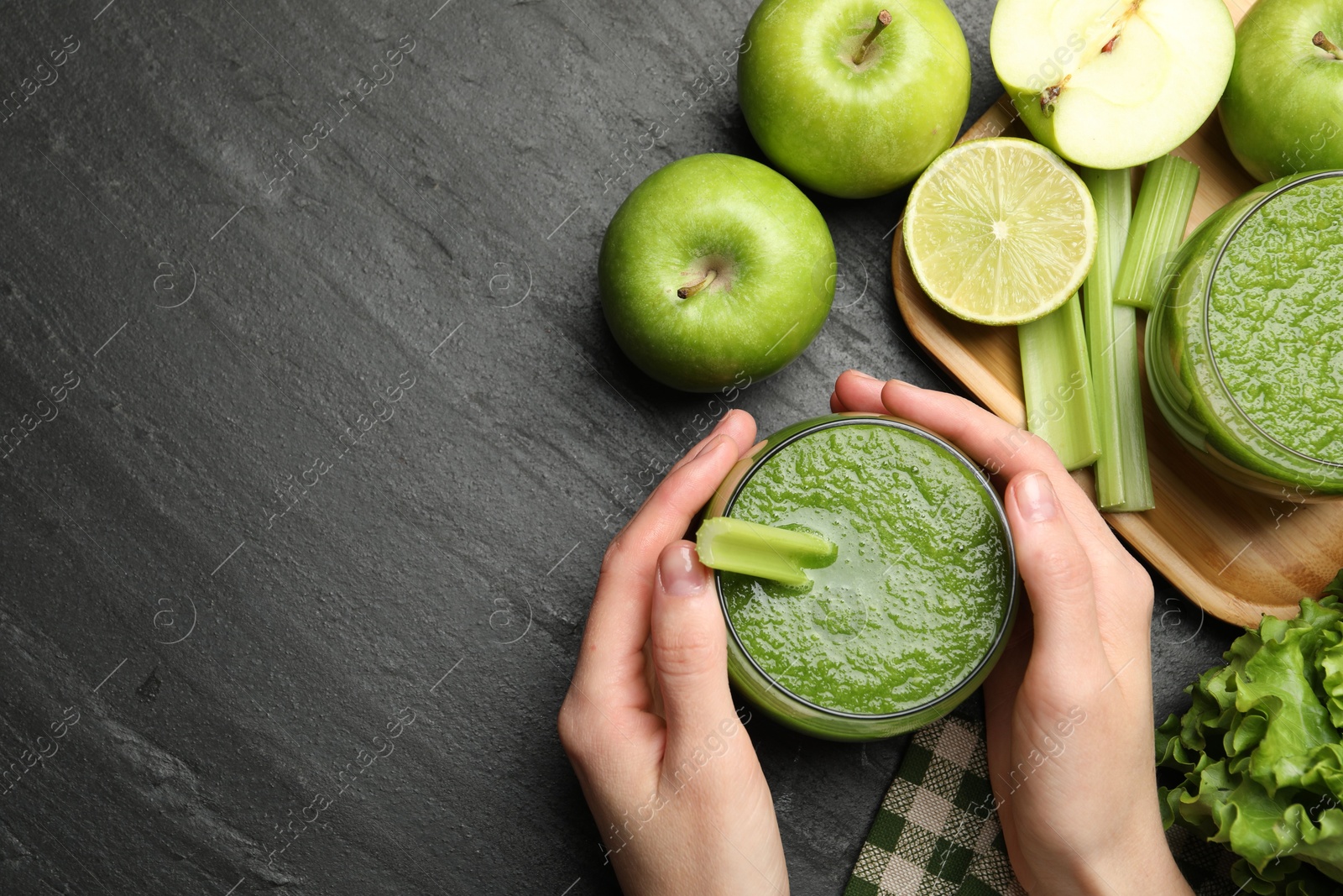 Superfood. Woman with glass of refreshing smoothie and ingredients at dark textured table, top view. Space for text Photo of Superfood. Woman with glass of refreshing smoothie and ingredients at dark textured table, top view. Space for text