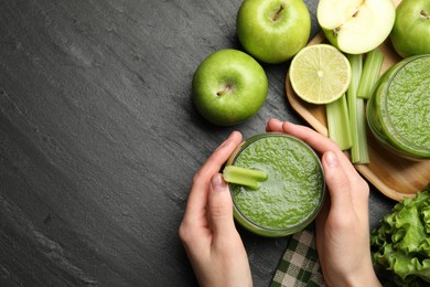 Photo of Superfood. Woman with glass of refreshing smoothie and ingredients at dark textured table, top view. Space for text
