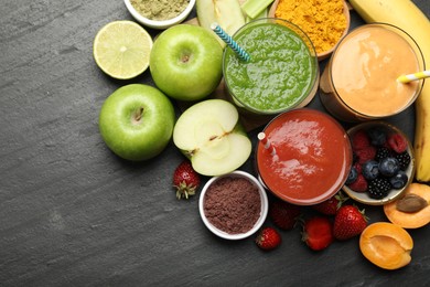 Photo of Superfood. Refreshing smoothies in glasses and ingredients on dark textured table, flat lay