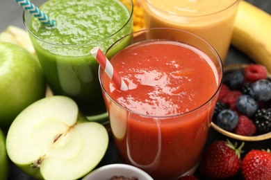 Photo of Superfood. Refreshing smoothies in glasses and ingredients on dark table, closeup