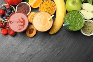 Photo of Superfood. Refreshing smoothies in glasses and ingredients on dark textured table, flat lay. Space for text