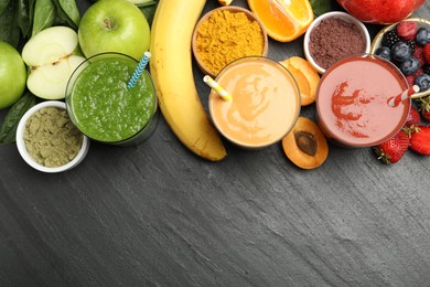 Photo of Superfood. Refreshing smoothies in glasses and ingredients on dark textured table, flat lay. Space for text