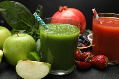 Photo of Superfood. Refreshing smoothies in glasses and ingredients on dark textured table against black background, closeup
