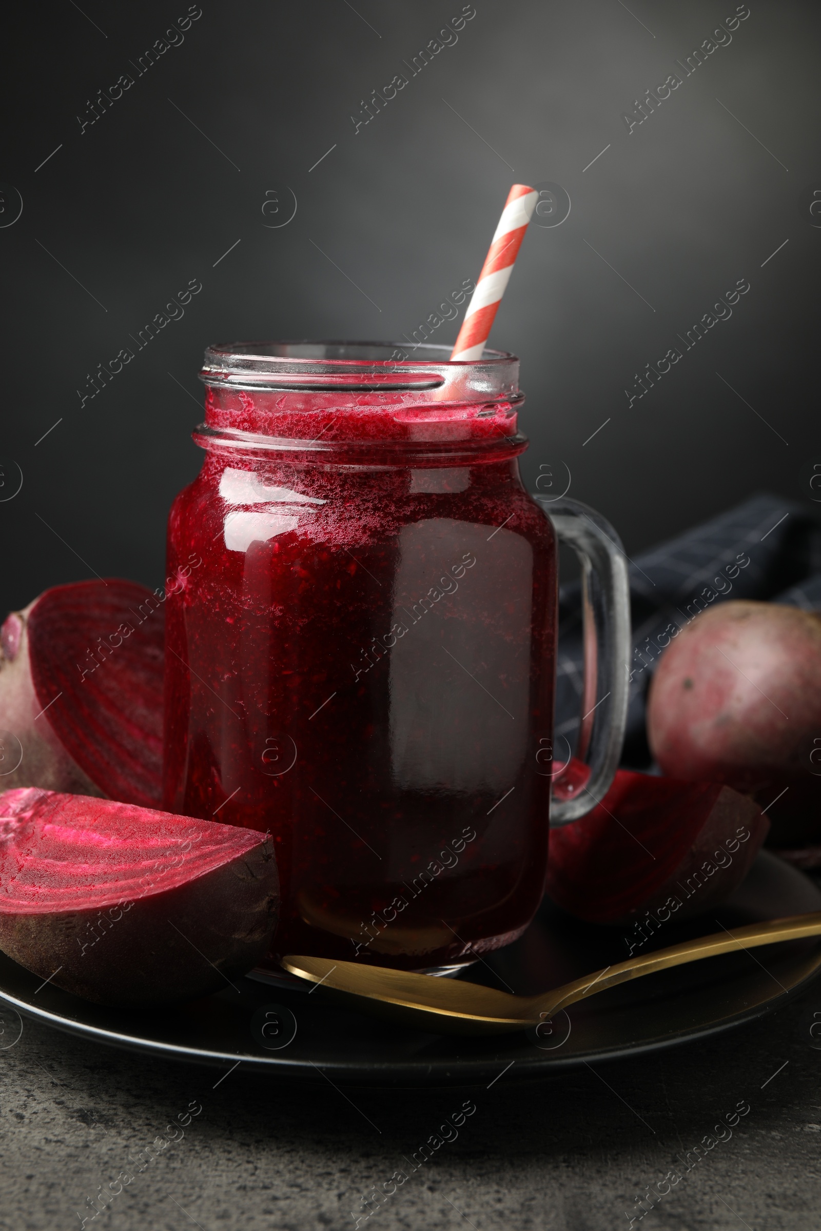 Superfood. Refreshing smoothie in mason jar and beetroot on grey textured table against dark background, closeup Photo of Superfood. Refreshing smoothie in mason jar and beetroot on grey textured table against dark background, closeup