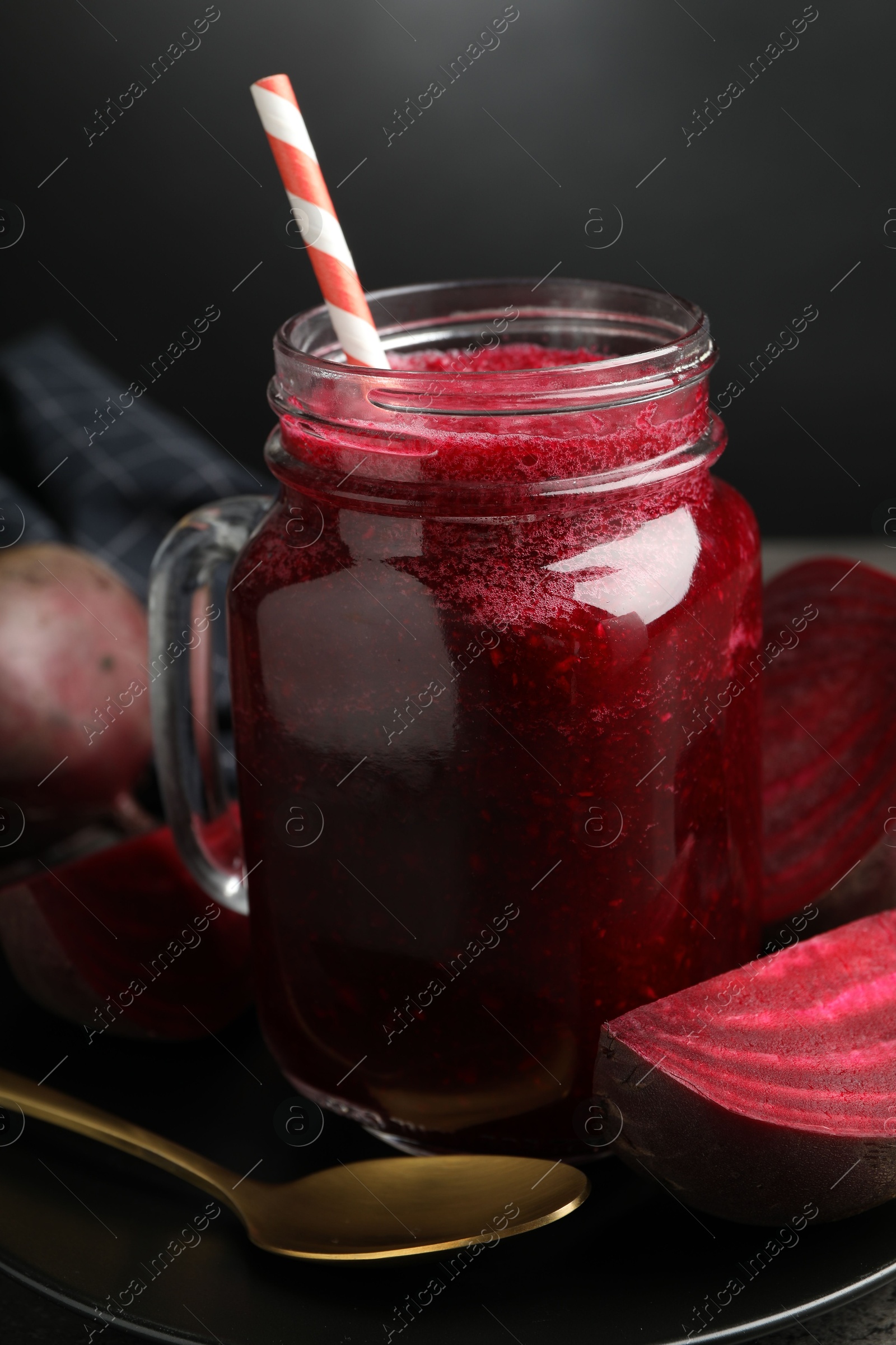 Photo of Superfood. Refreshing smoothie in mason jar and beetroot on table against dark background, closeup