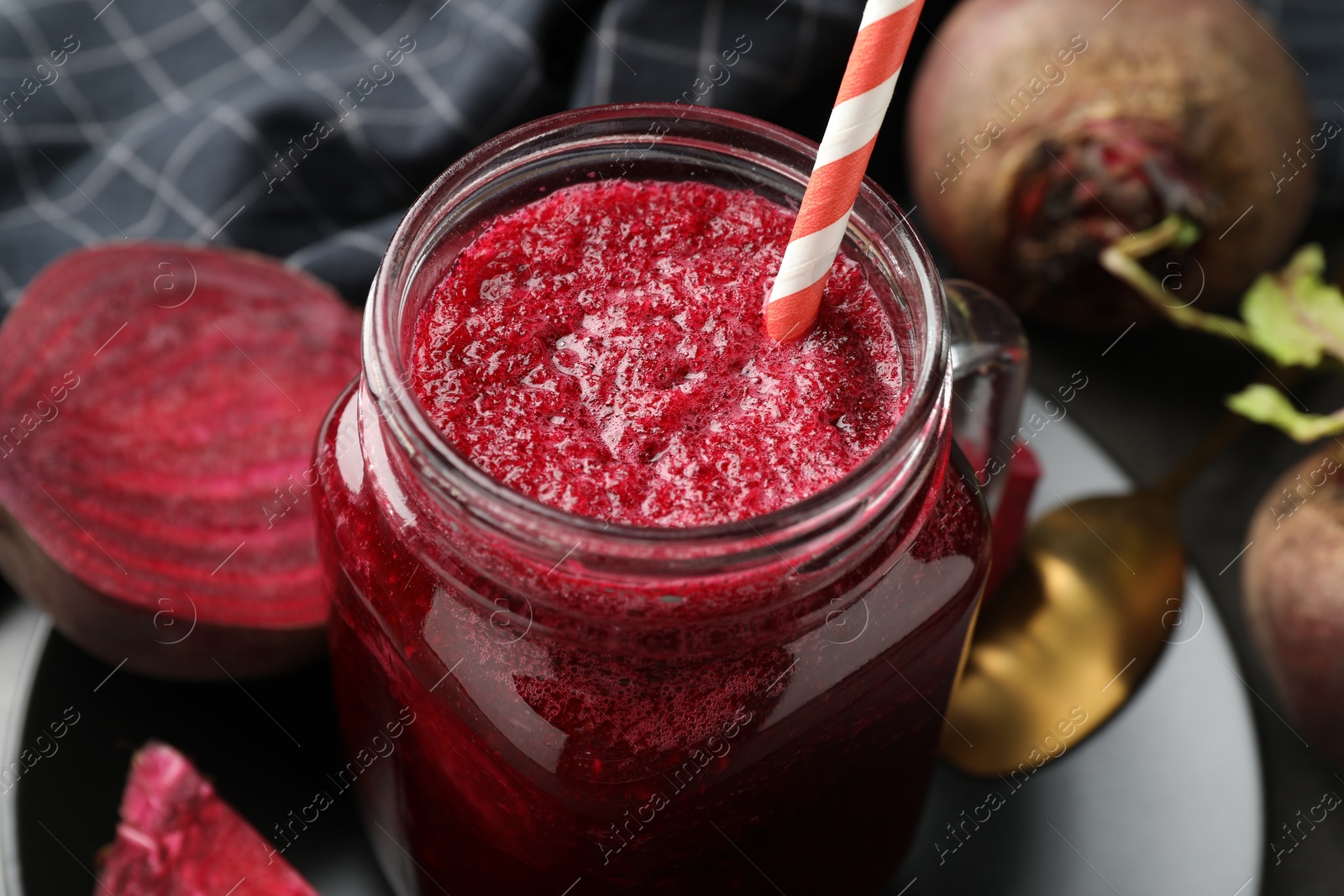 Photo of Superfood. Refreshing smoothie in mason jar and beetroots on dark table, closeup