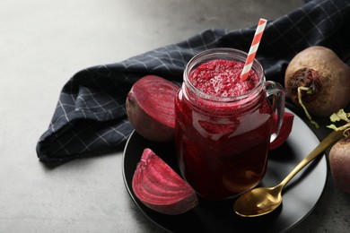 Photo of Superfood. Refreshing smoothie in mason jar and beetroots on dark textured table, closeup