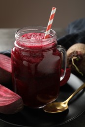 Photo of Superfood. Refreshing smoothie in mason jar and beetroots on grey table against brown background, closeup