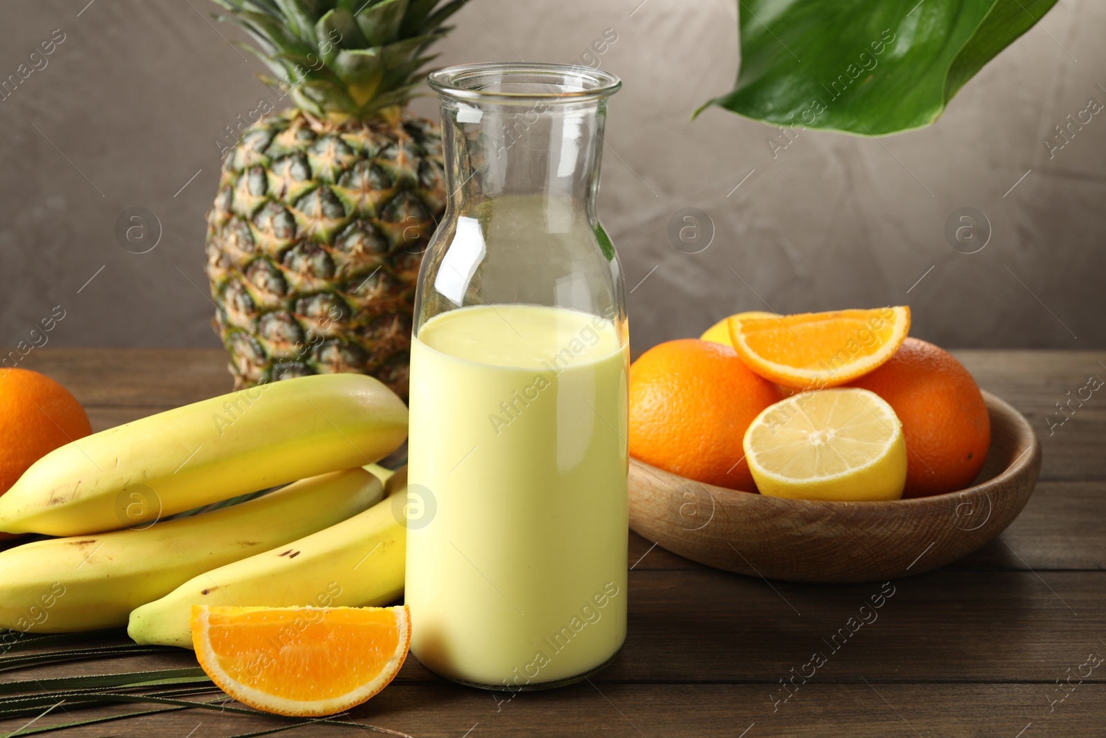 Superfood. Refreshing smoothie in bottle and ingredients on wooden table against grey background, closeup Photo of Superfood. Refreshing smoothie in bottle and ingredients on wooden table against grey background, closeup
