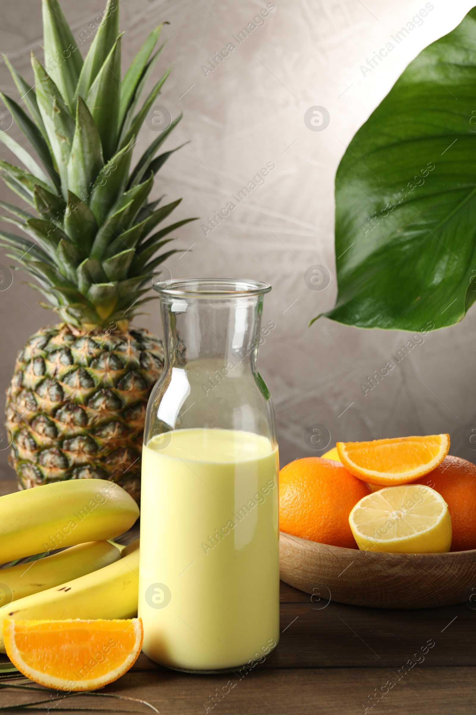 Superfood. Refreshing smoothie in bottle and ingredients on wooden table against grey background Photo of Superfood. Refreshing smoothie in bottle and ingredients on wooden table against grey background