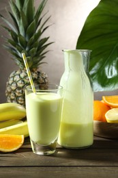 Photo of Superfood. Refreshing smoothie in bottle, glass and ingredients on wooden table against grey background
