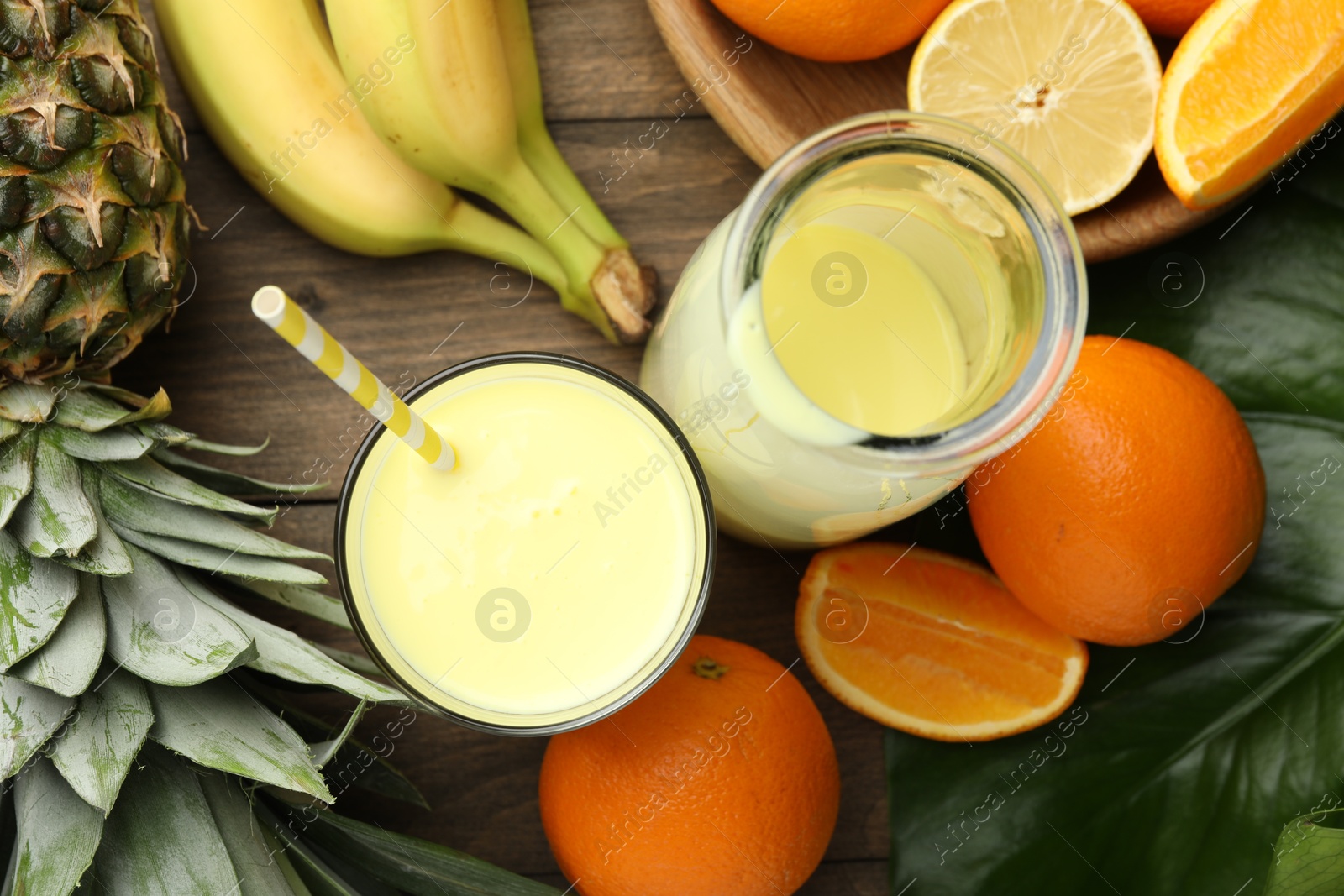 Superfood. Refreshing smoothie in bottle, glass and ingredients on wooden table, flat lay Photo of Superfood. Refreshing smoothie in bottle, glass and ingredients on wooden table, flat lay
