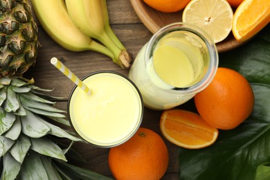Photo of Superfood. Refreshing smoothie in bottle, glass and ingredients on wooden table, flat lay