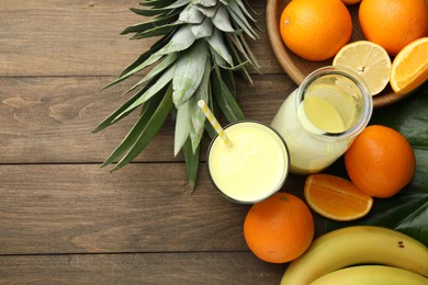 Photo of Superfood. Refreshing smoothie in bottle, glass and ingredients on wooden table, flat lay. Space for text