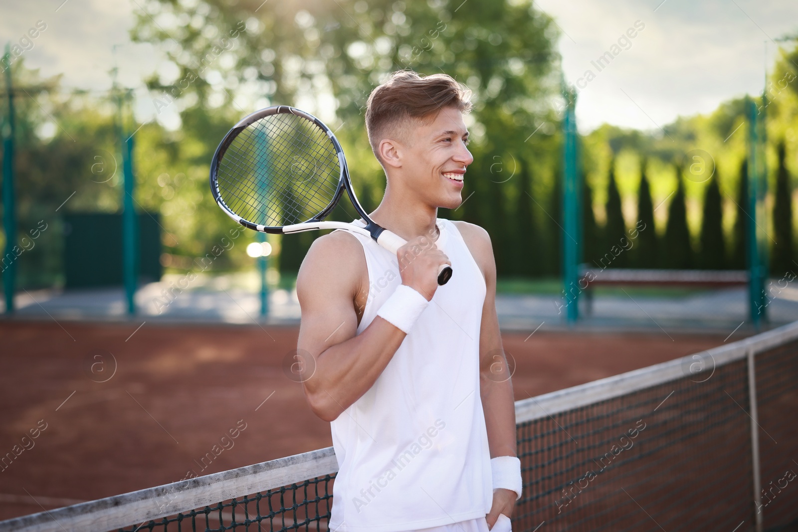 Happy man with racket at tennis court Photo of Happy man with racket at tennis court