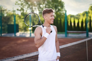 Photo of Happy man with racket at tennis court
