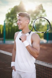 Photo of Happy man with racket at tennis court