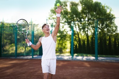 Photo of Young man playing tennis at court on sunny day. Space for text