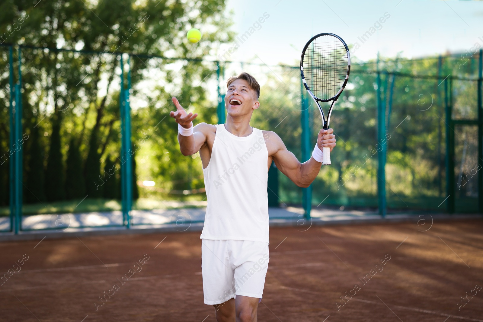 Young man playing tennis at court on sunny day Photo of Young man playing tennis at court on sunny day