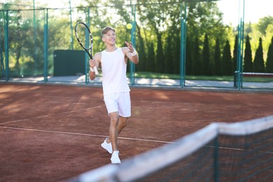 Photo of Young man playing tennis at court on sunny day