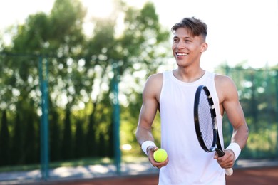Photo of Young man playing tennis at court on sunny day. Space for text