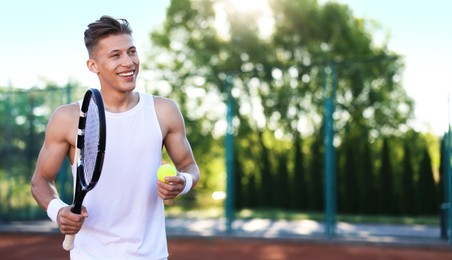 Photo of Young man playing tennis at court on sunny day. Space for text