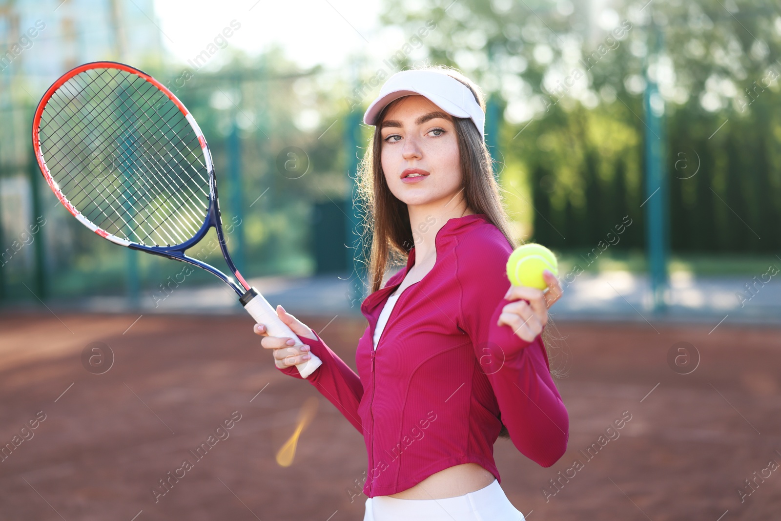 Beautiful woman with racket and ball at tennis court Photo of Beautiful woman with racket and ball at tennis court
