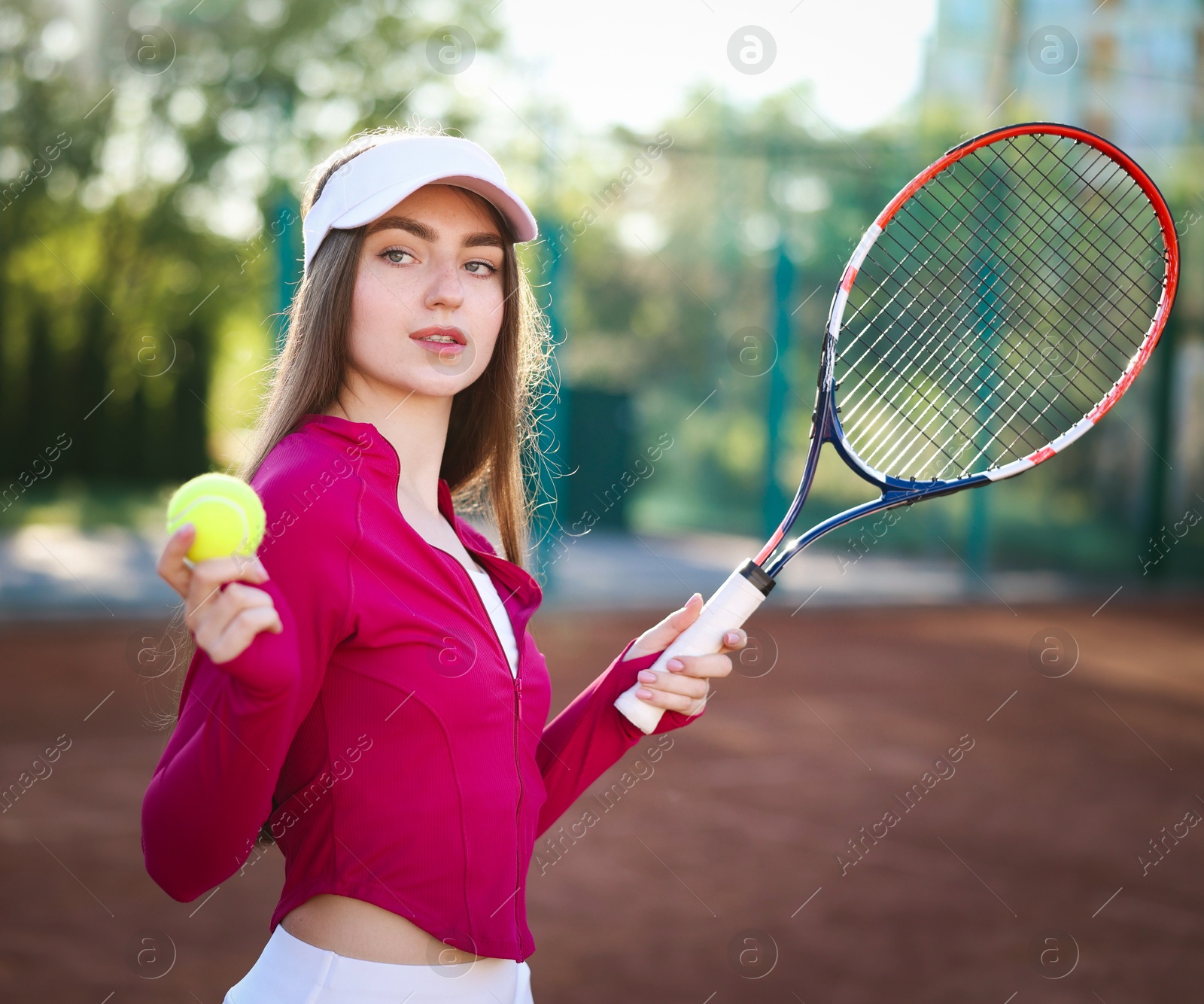 Beautiful woman with racket and ball at tennis court Photo of Beautiful woman with racket and ball at tennis court