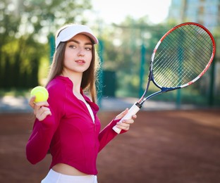Photo of Beautiful woman with racket and ball at tennis court