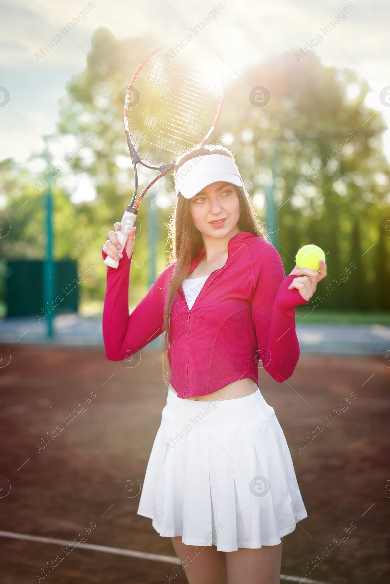Beautiful woman with racket and ball at tennis court Photo of Beautiful woman with racket and ball at tennis court