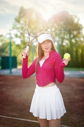 Photo of Beautiful woman with racket and ball at tennis court