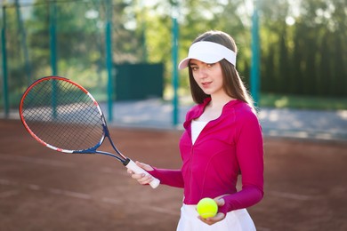Photo of Beautiful woman with racket and ball at tennis court