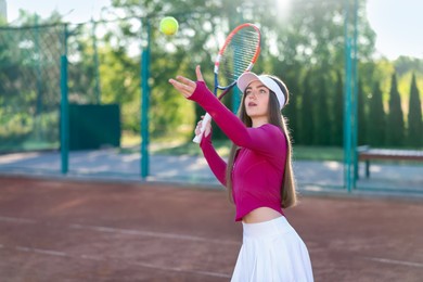 Photo of Beautiful woman playing tennis at court on sunny day. Space for text