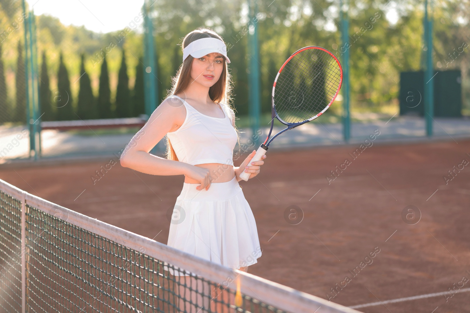 Beautiful woman with racket at tennis court Photo of Beautiful woman with racket at tennis court